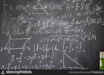 math formulas in white chalk on black board. math formulas on black board