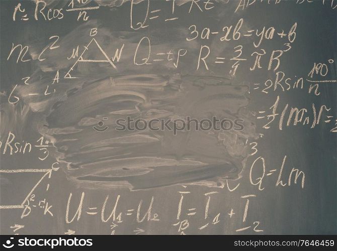 math formulas written in white chalk and copy space on black board, retro toned. math formulas on black board