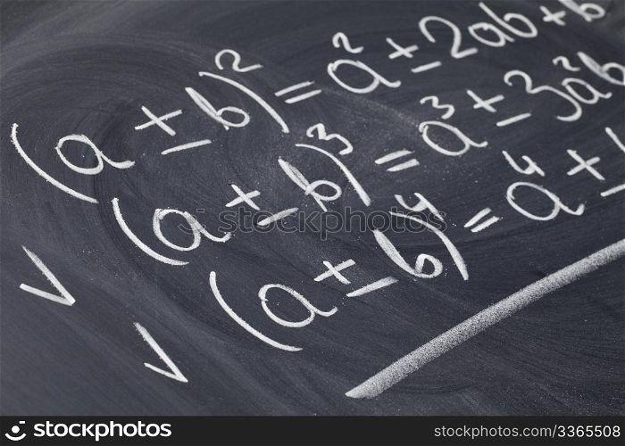 mathematical education concept - algebra equations handwritten with white chalk on blackboard
