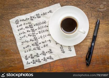 mathematical equations of physics - handwriting on a napkin with a cup of coffee on a rustic wooden table
