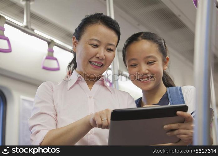 Mather and daughter watching a movie in the subway