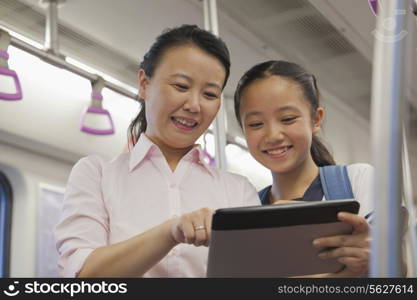 Mather and daughter watching a movie in the subway