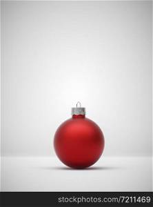 Matte red Christmas ball centered on a light grey background for seasonal Holiday celebrations and themes