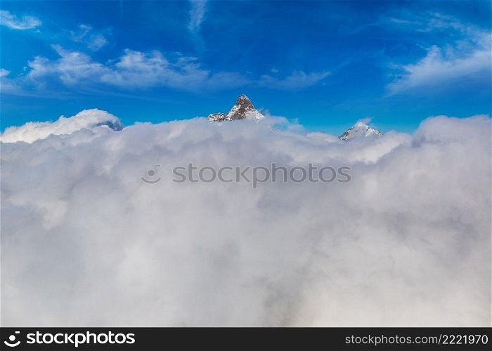 Matterhorn peak above clouds in Switzerland, in a summer day