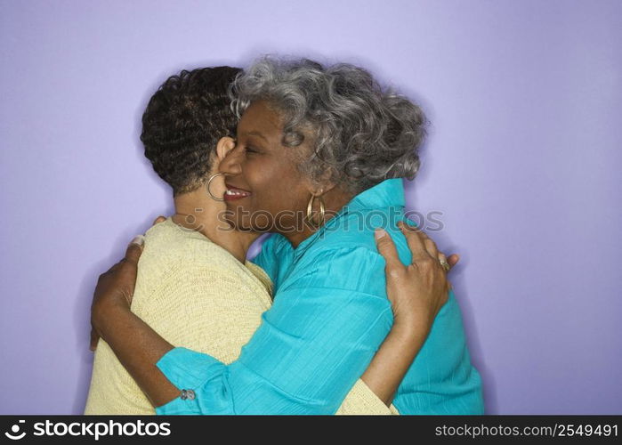 Mature adult African American females embracing.