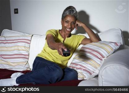Mature African American Woman On Sofa Watching TV