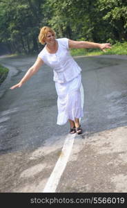 mature aged old senior woman walk and balance on road in fresh nature