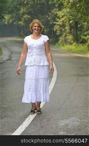 mature aged old senior woman walk and balance on road in fresh nature