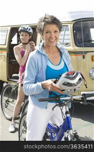 mature and mid adult women prepare for a cycle ride