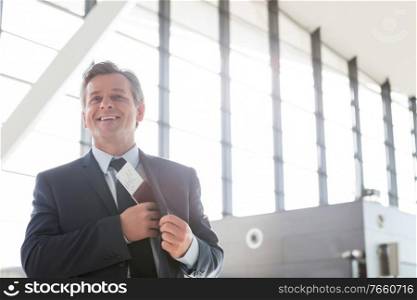 Mature attractive businessman taking out his passport from his suit in airport
