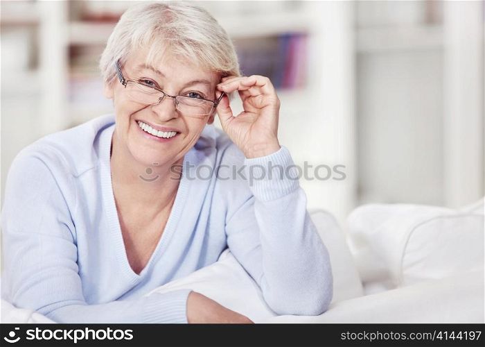 Mature attractive woman with glasses on the sofa