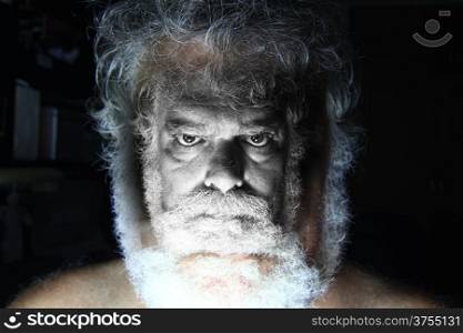 Mature bearded man with angry face staring