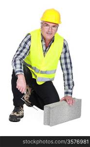 mature bricklayer with concrete block and trowel