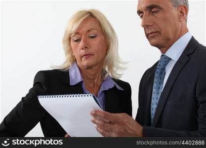Mature business couple looking at a document
