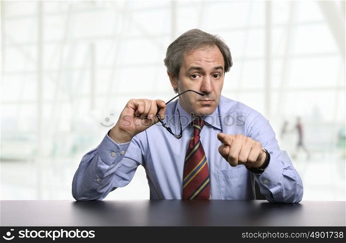 mature business man on a desk pointing, at the office