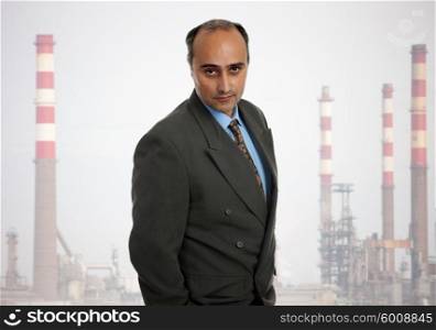 mature business man with a refinery as background