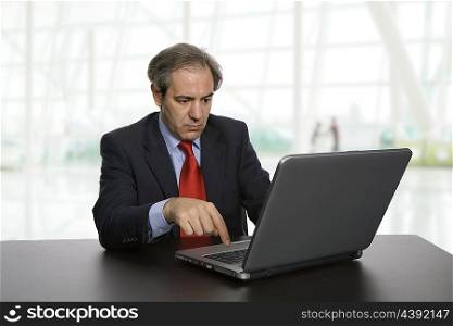 mature business man working with his laptop, at the office