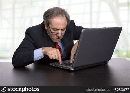 mature business man working with his laptop at the office