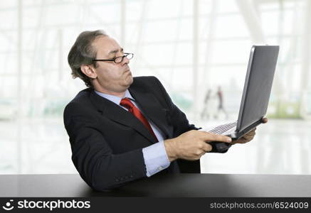 mature business man working with his laptop at the office. worried