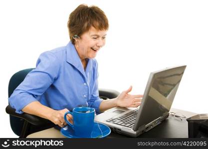 Mature business woman chatting on her blue tooth and looking at her laptop computer. Isolated on white.