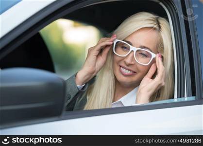 Mature business woman in a car is looking away