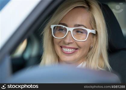 Mature business woman in a car is looking away