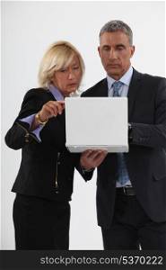 Mature businessman and businesswoman in front of computer