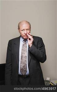 Mature businessman chewing his pen