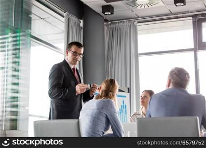 Mature businessman discussing with colleagues in board room