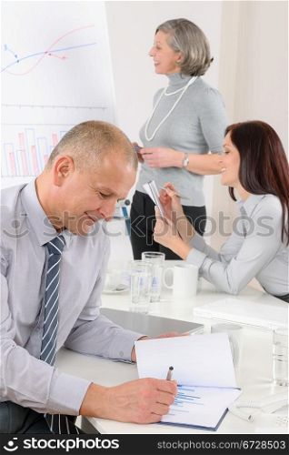 Mature businessman during team meeting with colleagues give presentation