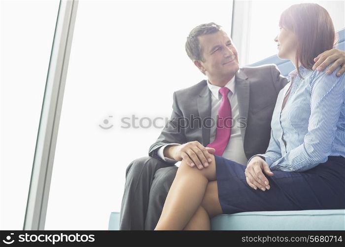 Mature businessman flirting with female colleague in office