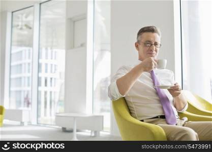 Mature businessman having coffee at office lobby