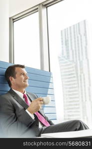 Mature businessman having coffee in office