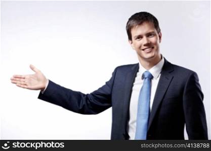 Mature businessman in a suit shows a hand in the direction