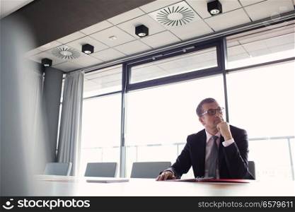 Mature businessman listening to meeting in board room