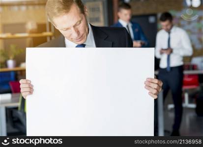 mature businessman looking blank white placard