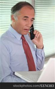 mature businessman on the phone looks stunned