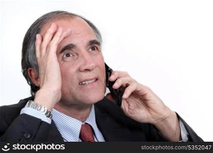 mature businessman on the phone trying to solve problem