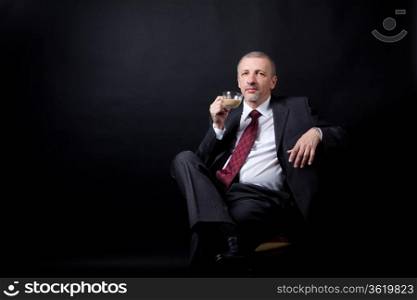 Mature businessman sitting and drinking coffee with milk