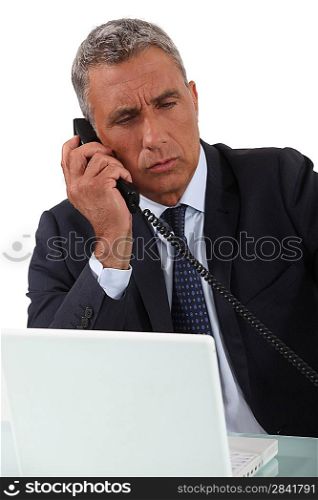 Mature businessman taking important call