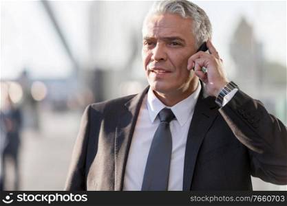 Mature businessman talking on smartphone in airport