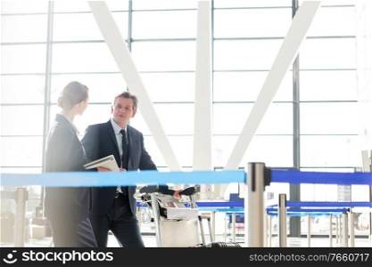 Mature businessman talking with his business partner in check in are at airport
