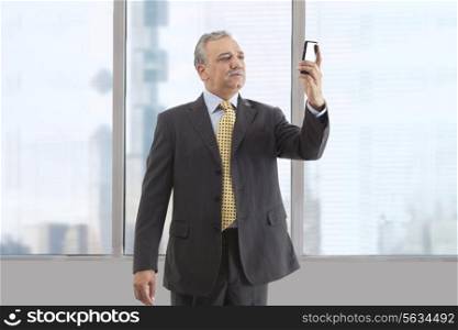 Mature businessman text messaging at office