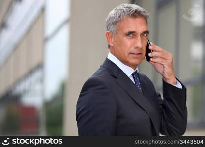 Mature businessman using a cellphone outside