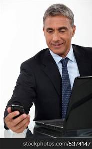 Mature businessman with a laptop and cellphone