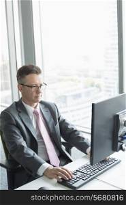 Mature businessman working on computer in office