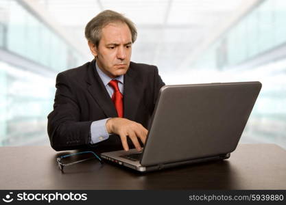 mature businessman working with his laptop, at the office