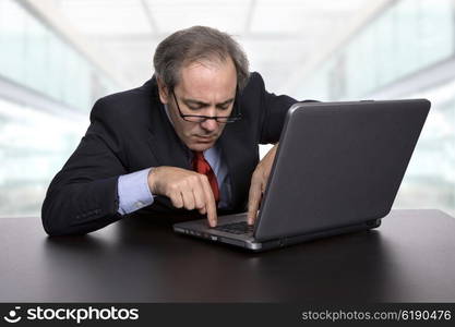 mature businessman working with his laptop, at the office