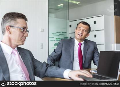 Mature businessmen discussing in office