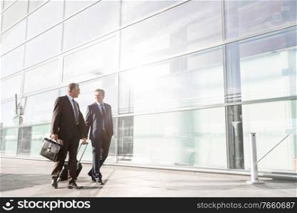 Mature businessmen walking while talking in the airport